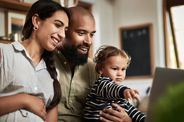 mom and dad with their young son looking at the laptop